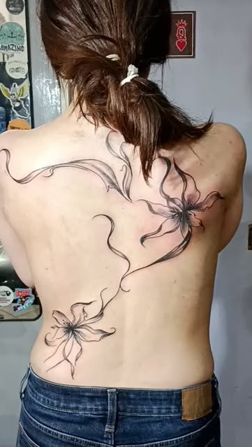 Tatuaje de líneas finas con diseño floral en la espalda