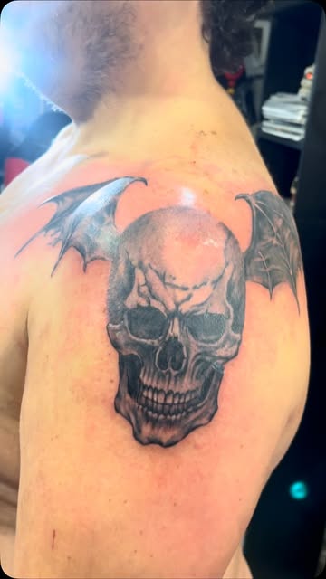 Tatuaje de calavera con alas en el hombro